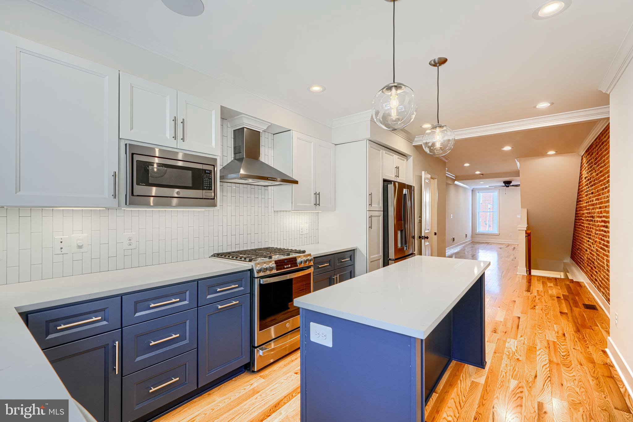 1427 Patapsco Street Baltimore, MD 21230 - Photo 12 of 34 a kitchen with stainless steel appliances granite countertop a sink a stove and a wooden floors