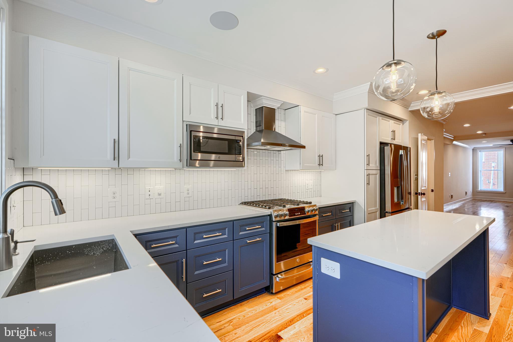1427 Patapsco Street Baltimore, MD 21230 - Photo 13 of 34 a kitchen with stainless steel appliances granite countertop a sink a stove and a refrigerator