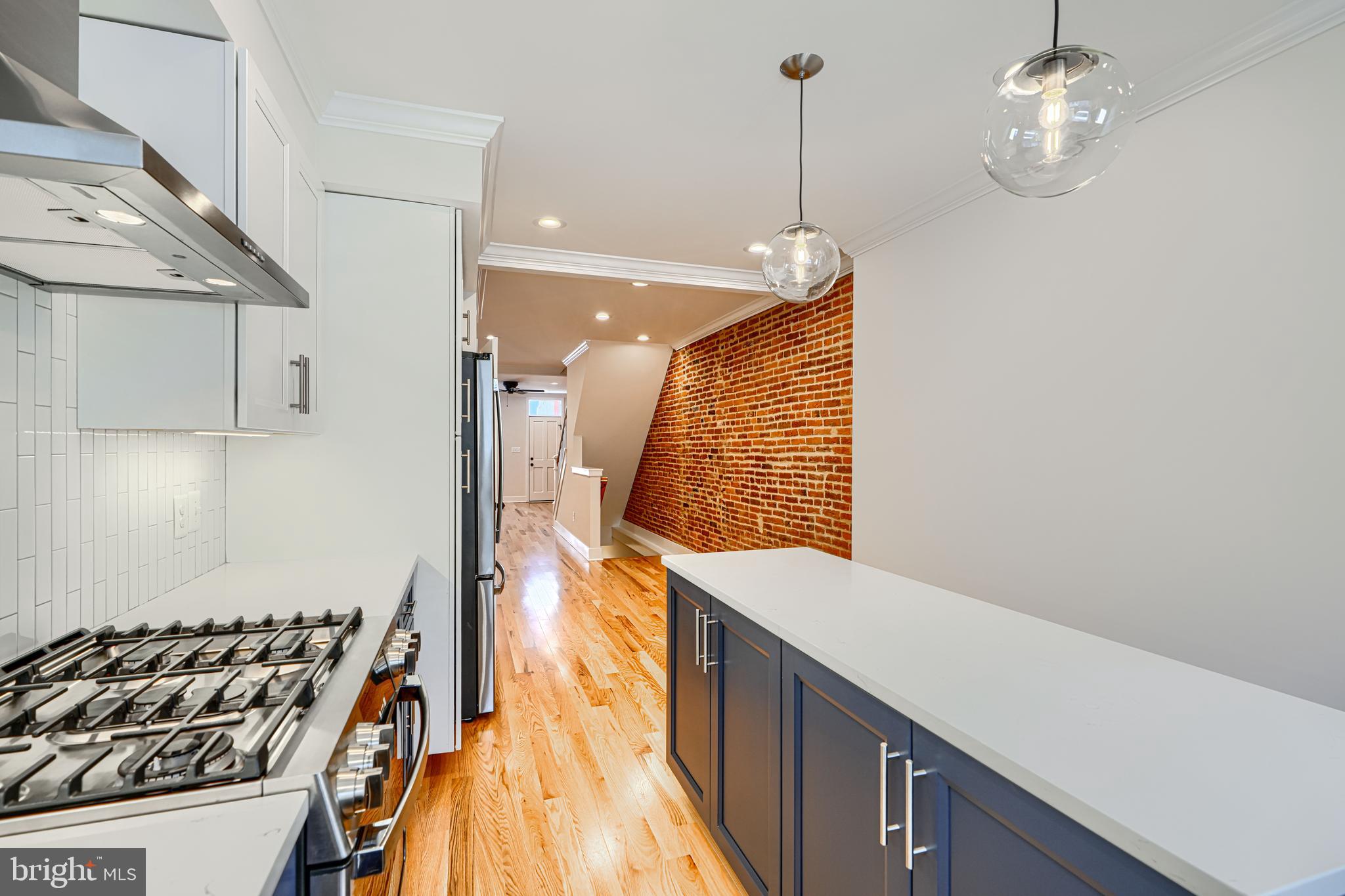 1427 Patapsco Street Baltimore, MD 21230 - Photo 14 of 34 a kitchen with a sink a stove and a wooden floor
