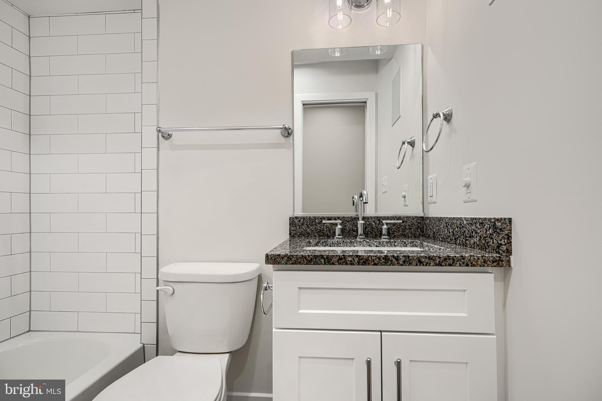 1427 Patapsco Street Baltimore, MD 21230 - Photo 17 of 34 a bathroom with a granite countertop toilet sink and mirror