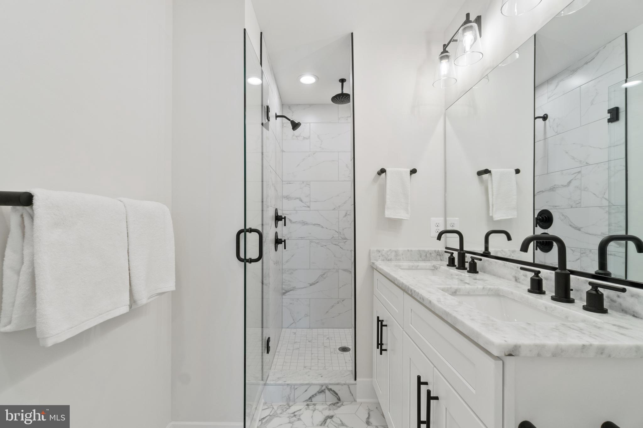 1427 Patapsco Street Baltimore, MD 21230 - Photo 17 of 20 a bathroom with a granite countertop sink a mirror and shower