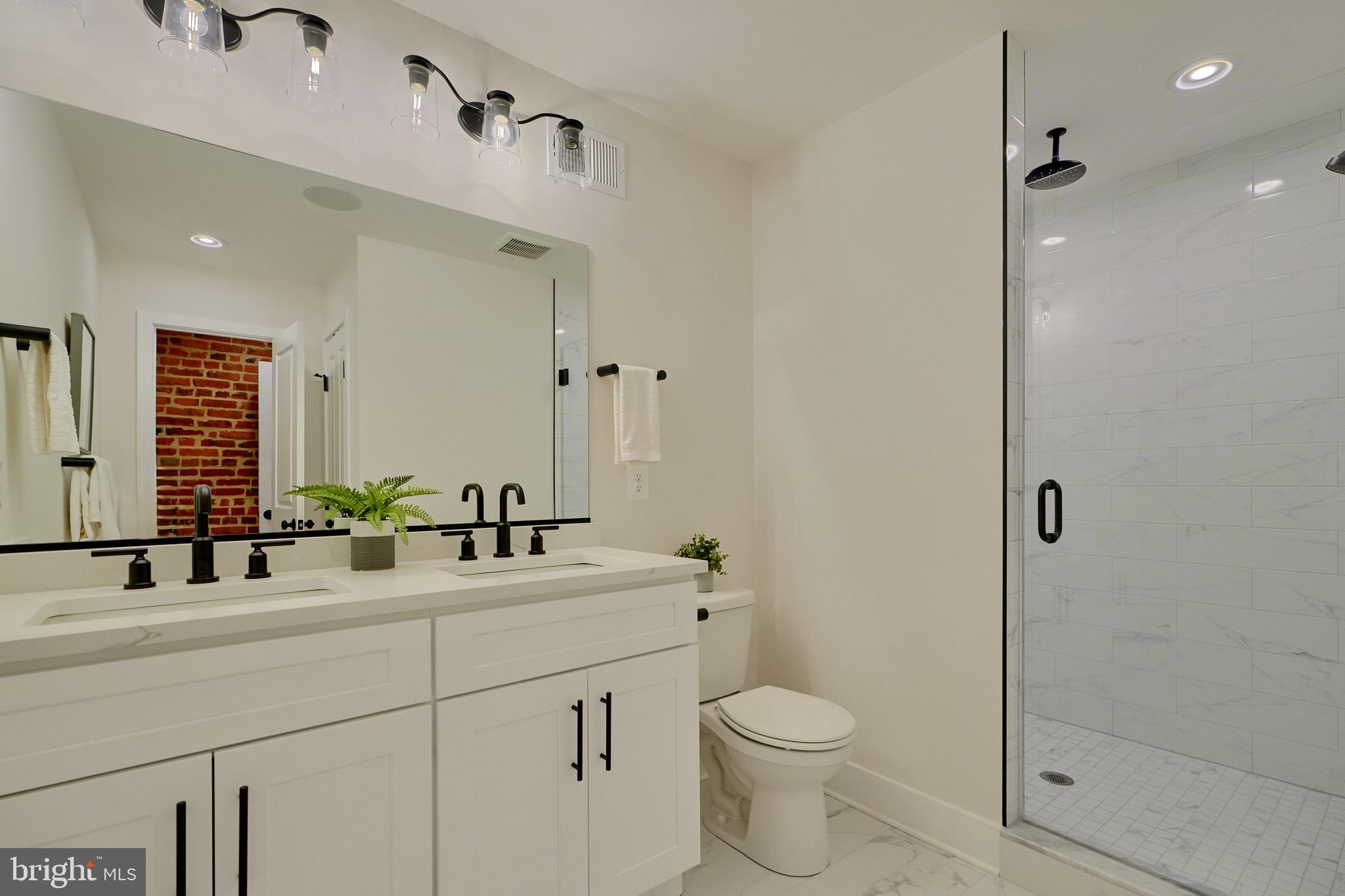 1427 Patapsco Street Baltimore, MD 21230 - Photo 18 of 20 a bathroom with a double vanity sink toilet and shower