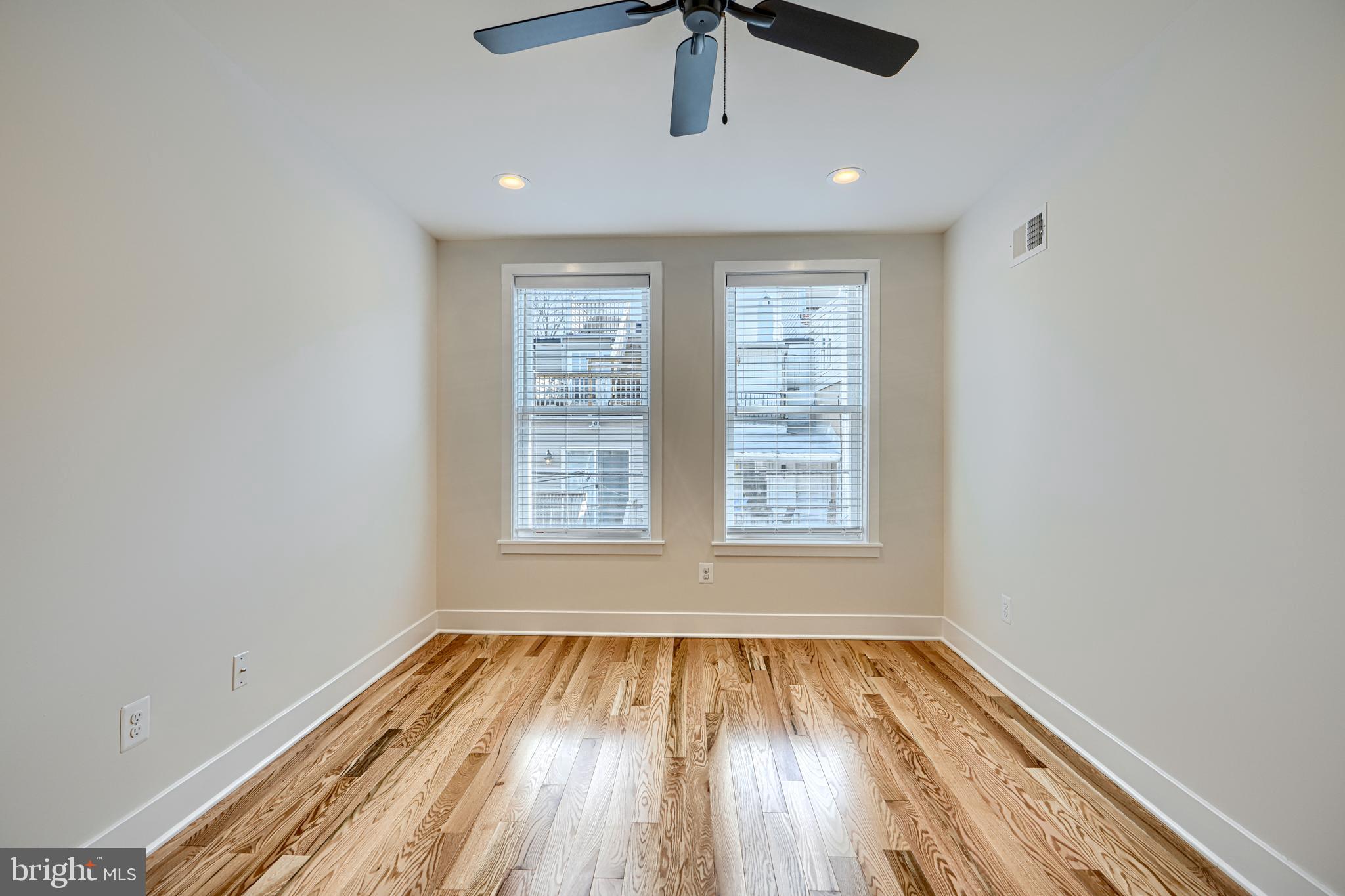1427 Patapsco Street Baltimore, MD 21230 - Photo 24 of 34 an empty room with wooden floor cabinet and windows