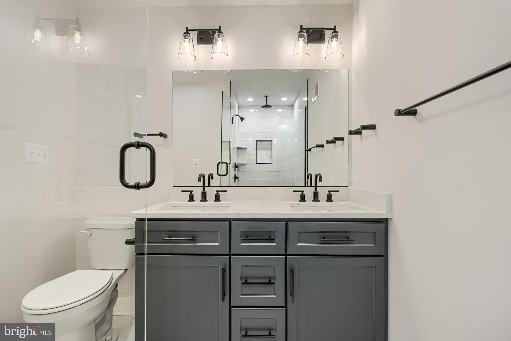1427 Patapsco Street Baltimore, MD 21230 - Photo 30 of 34 a bathroom with a double vanity sink toilet and mirror