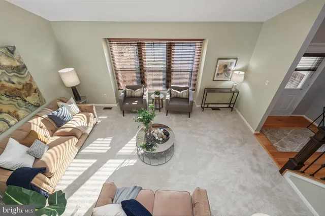 a living room with stainless steel appliances kitchen island granite countertop furniture and a wooden floor