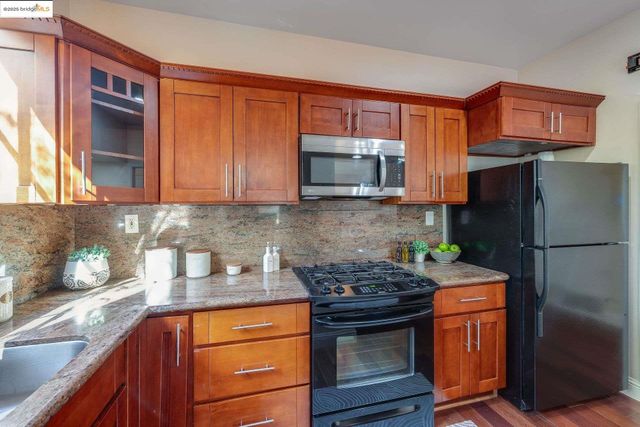 a kitchen with granite countertop wooden cabinets and a stove top oven