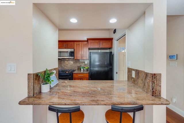 a kitchen with stainless steel appliances granite countertop a refrigerator stove top oven a sink and dishwasher
