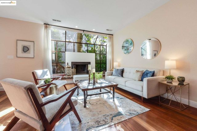 a living room with fireplace furniture and a large window