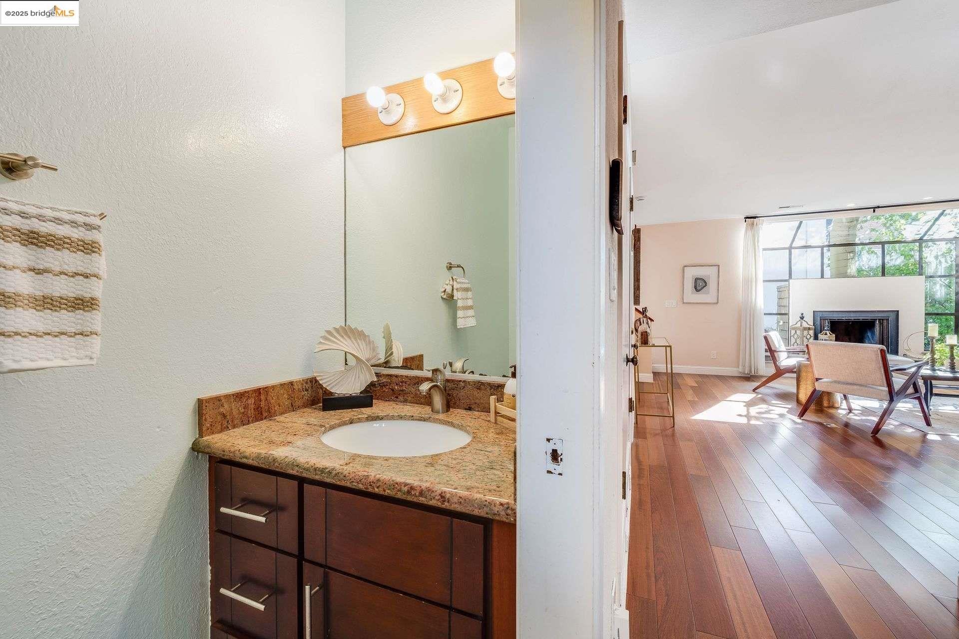 2316 Blake Street, Unit D Berkeley, CA 94704 - Photo 7 of 31 Bathroom with vanity, hardwood / wood-style floors, a fireplace, and a textured wall