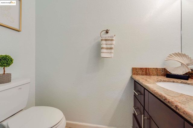 a bathroom with a granite countertop toilet and sink
