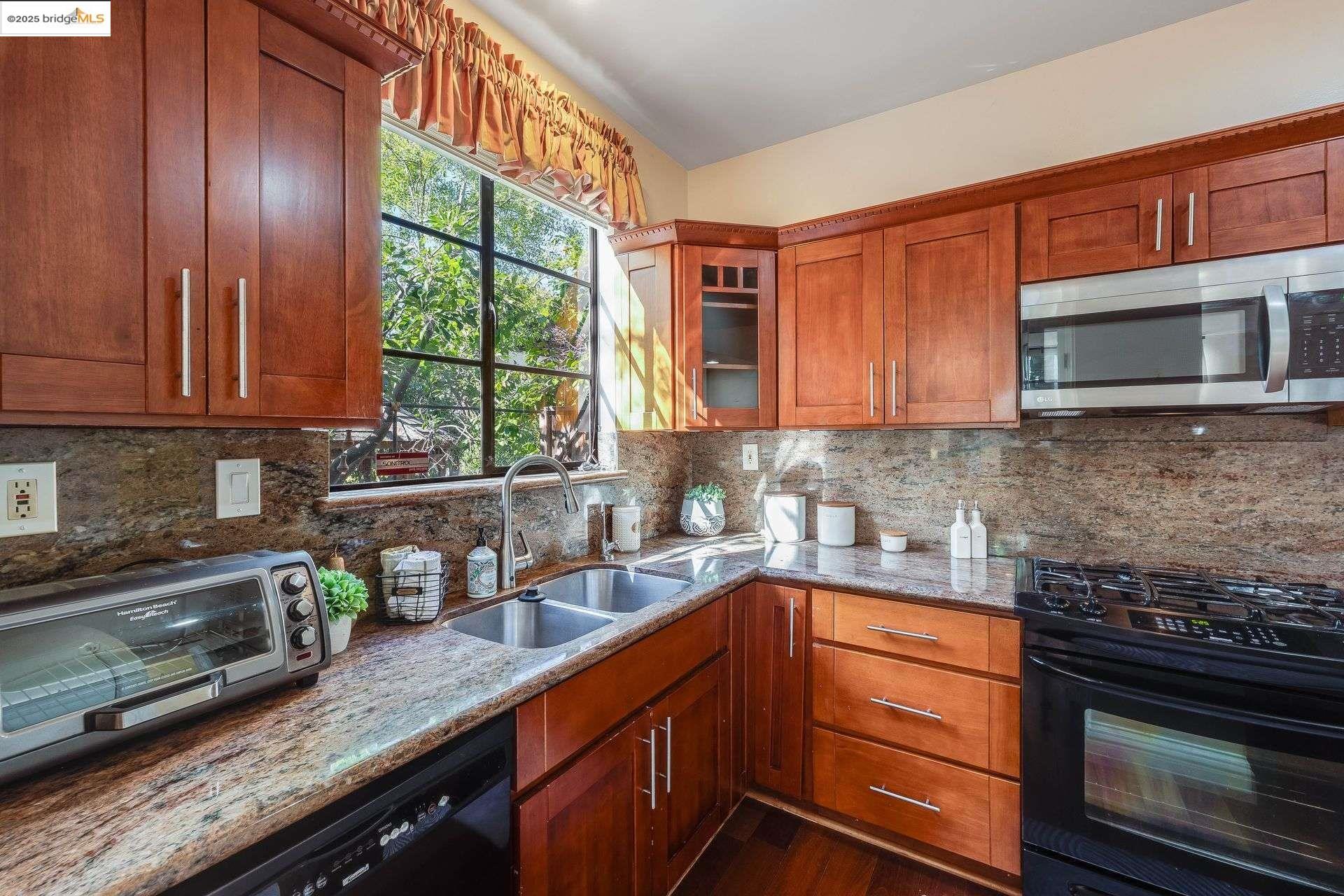 2316 Blake Street, Unit D Berkeley, CA 94704 - Photo 9 of 31 Kitchen featuring black appliances, brown cabinetry, light stone counters, and decorative backsplash