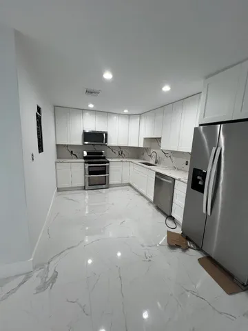 a kitchen with stainless steel appliances a refrigerator and a stove top oven