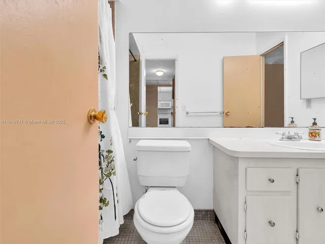a bathroom with a toilet a sink and mirror