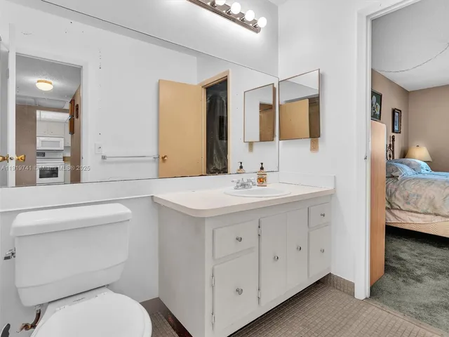 a bathroom with a toilet sink and mirror