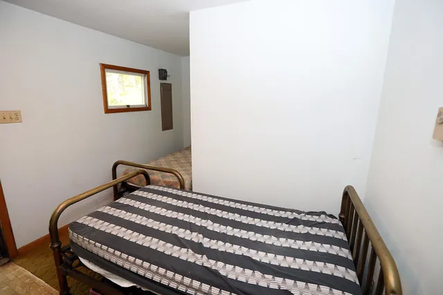 a bedroom with a bed and a window