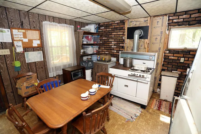 a kitchen with stainless steel appliances kitchen island granite countertop a table chairs in it and wooden floors