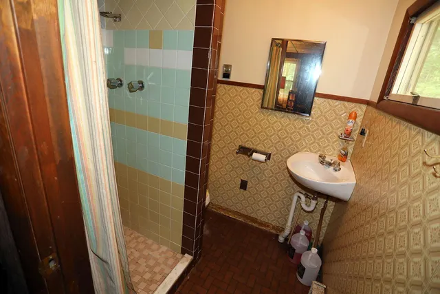 a bathroom with a sink a mirror and shower