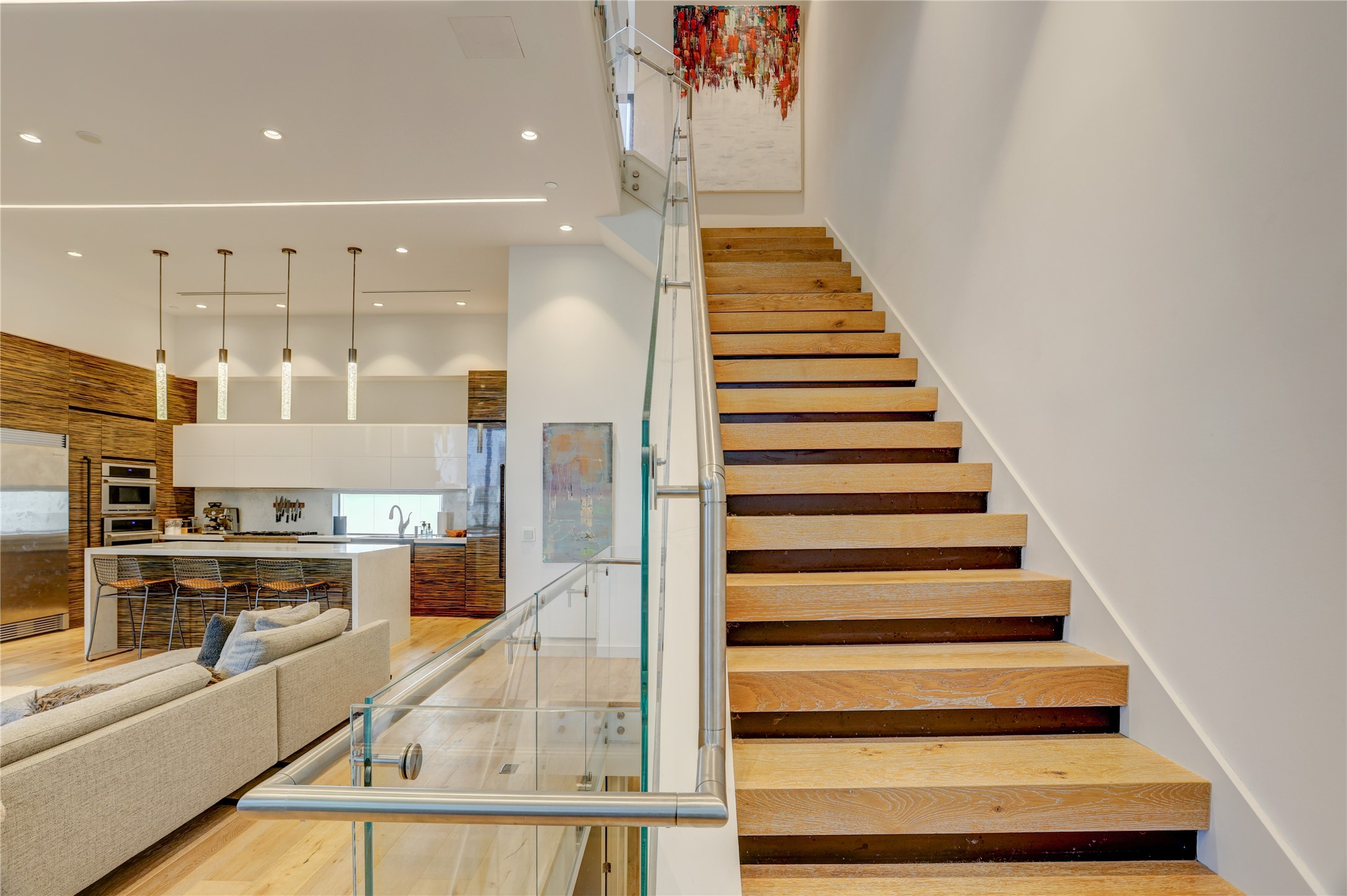 1807 Indiana Street Houston, TX 77006 - Photo 18 of 35 Staircase Overview: Sleek glass-panel handrail system, connecting the second-floor living space to the third-floor landing.