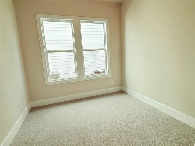 a view of a hallway with wooden floor and a window