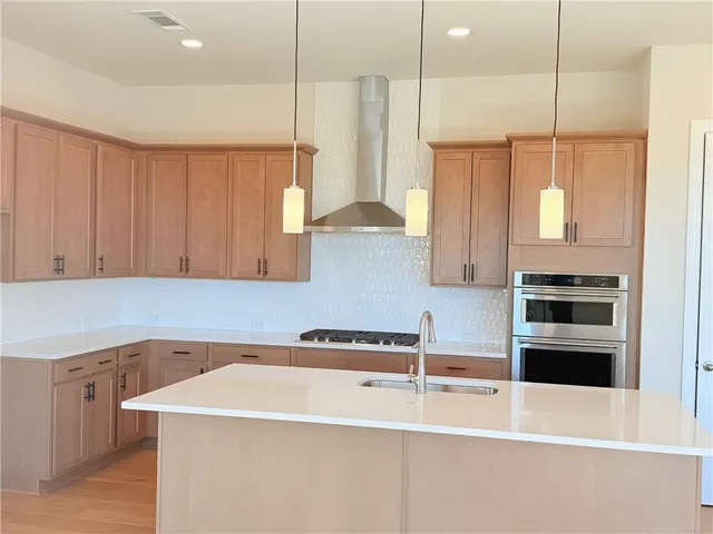 a kitchen with stainless steel appliances granite countertop a sink a stove and a refrigerator