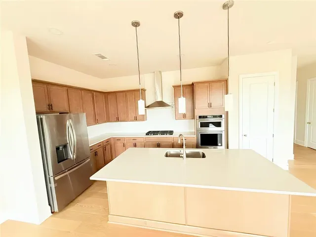 a kitchen with kitchen island a large counter top space appliances and a ceiling fan