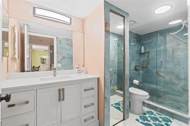 a bathroom with a double vanity sink toilet and shower