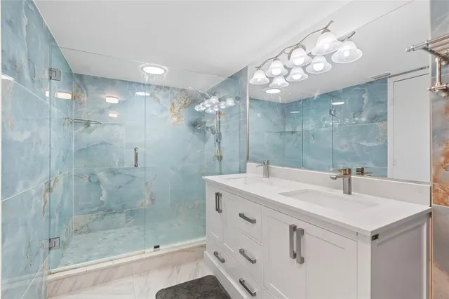 a bathroom with a sink a large mirror and shower