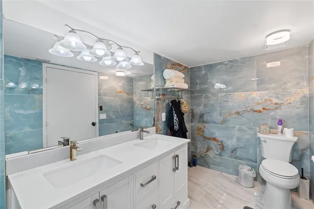 a bathroom with a sink vanity mirror and toilet