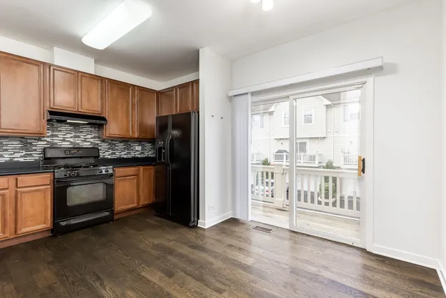 a kitchen with granite countertop a refrigerator stove top oven and sink