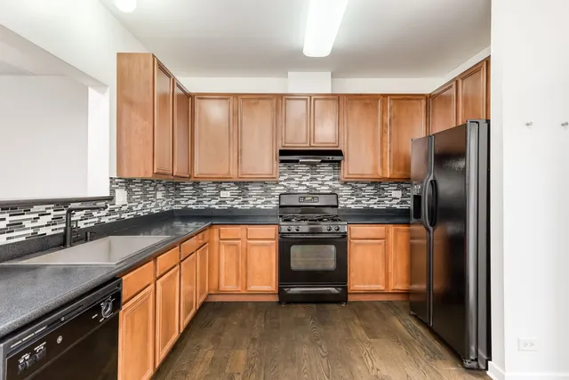 a kitchen with stainless steel appliances granite countertop a refrigerator and a sink