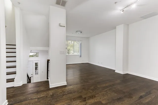 a view of empty room with wooden floor