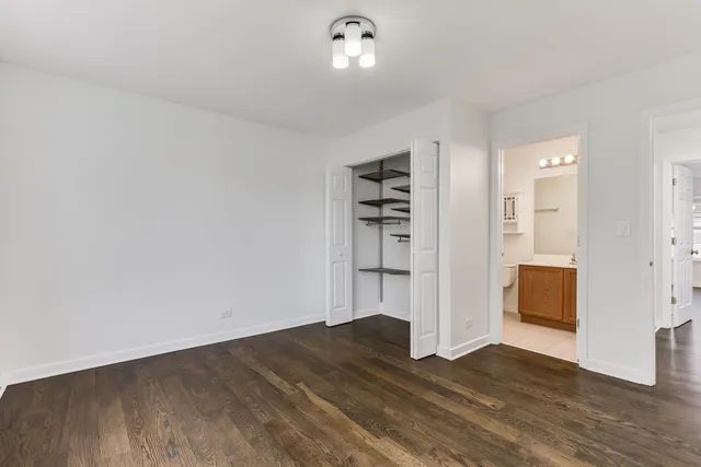 an empty room with wooden floor and cabinet