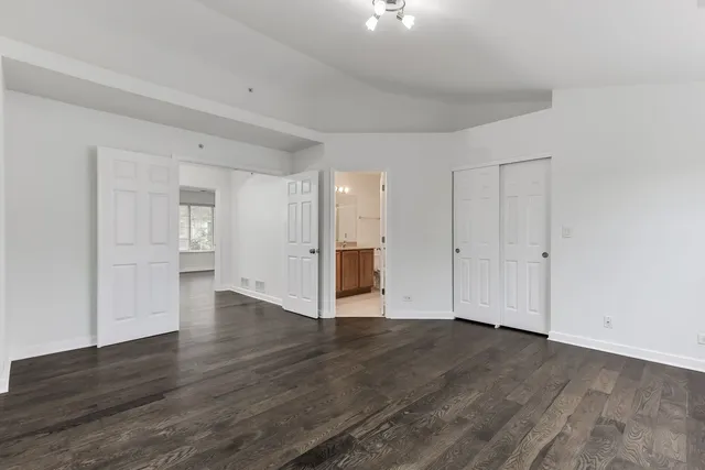 a view of an empty room with wooden floor