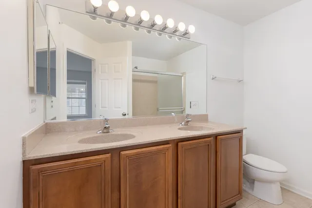 a bathroom with a sink a toilet and a mirror