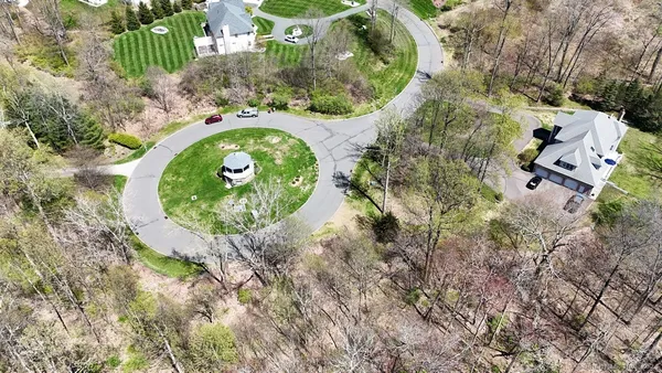 an aerial view of a house with a yard and tennis court
