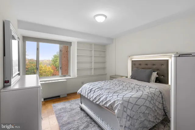 a bedroom with a bed and a large window