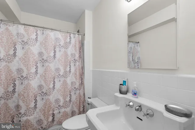 a bathroom with a sink vanity mirror and toilet