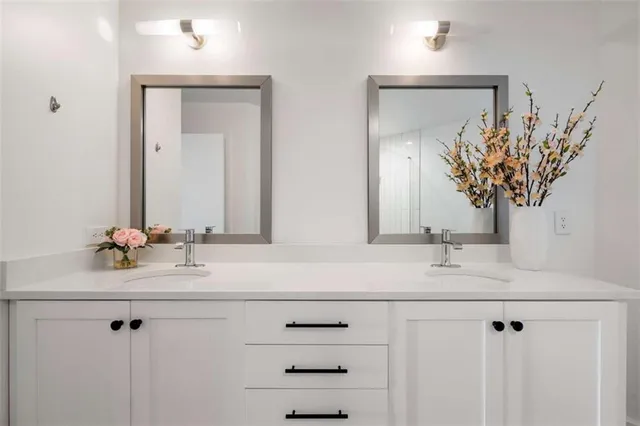 a bathroom with a double vanity sink mirror and toilet