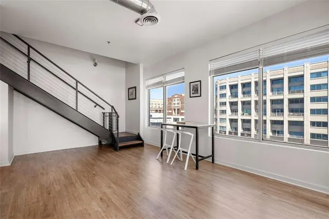 a view of an empty room with a window and wooden floor