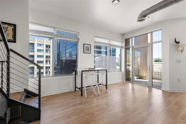 a kitchen with a sink dishwasher a stove and white cabinets with wooden floor
