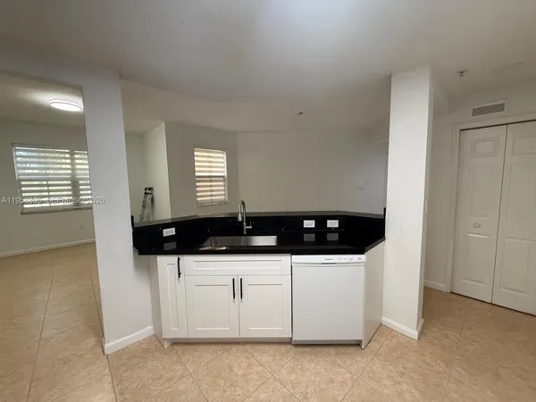 a kitchen with a sink and white cabinets