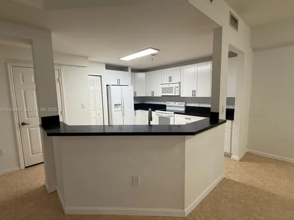 a kitchen with stainless steel appliances granite countertop a sink a stove a refrigerator a microwave and island