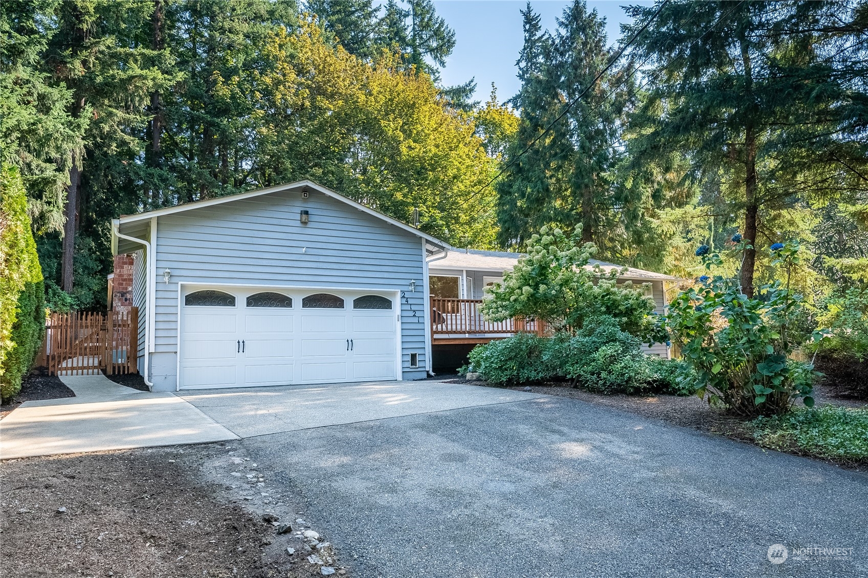 24121 6th Place West Bothell, WA 98021 - Photo 27 of 32 a view of a house with potted plants and large trees