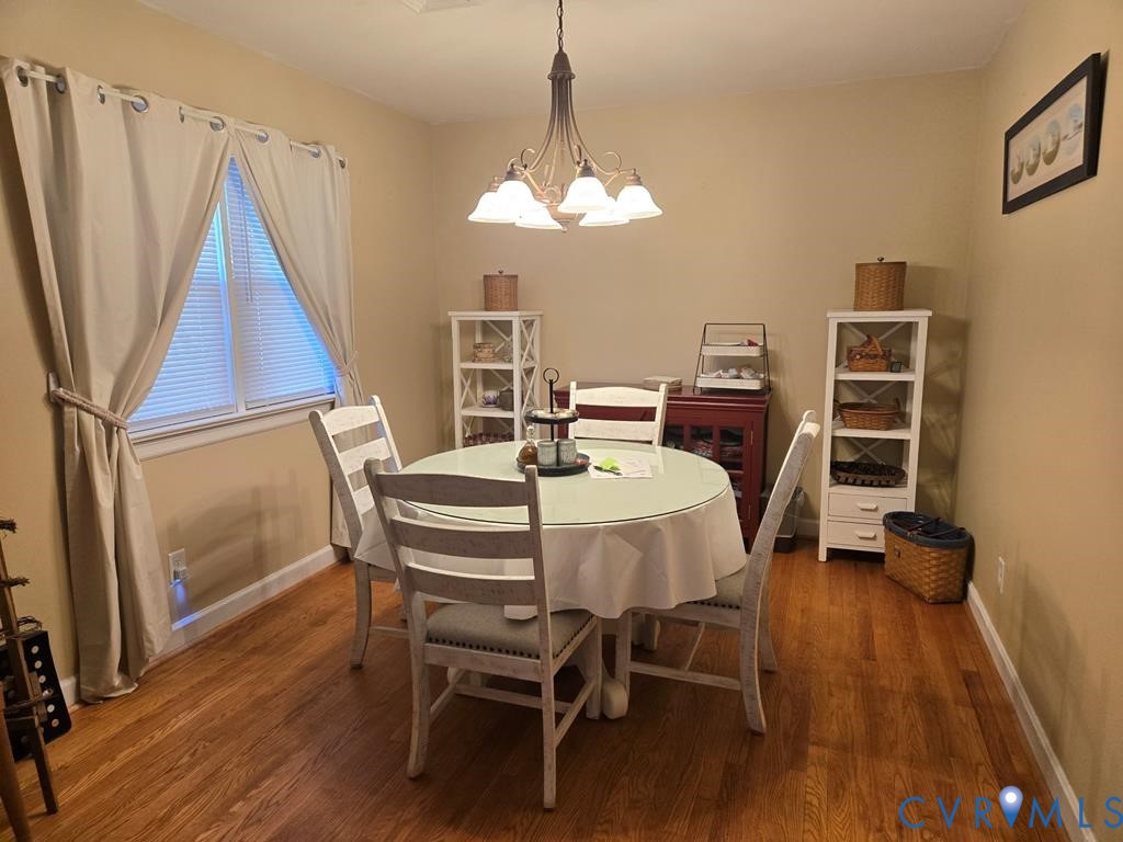 6 Mahan Road Farmville, VA 23901 - Photo 4 of 30 a dining room with wooden floor a chandelier a wooden table and chairs