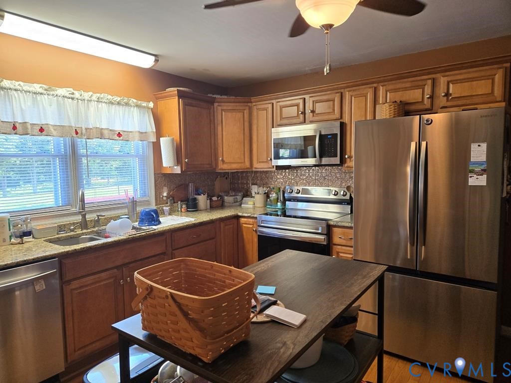 6 Mahan Road Farmville, VA 23901 - Photo 5 of 30 a kitchen with stainless steel appliances granite countertop a refrigerator a stove a sink dishwasher a dining table and chairs with wooden floor