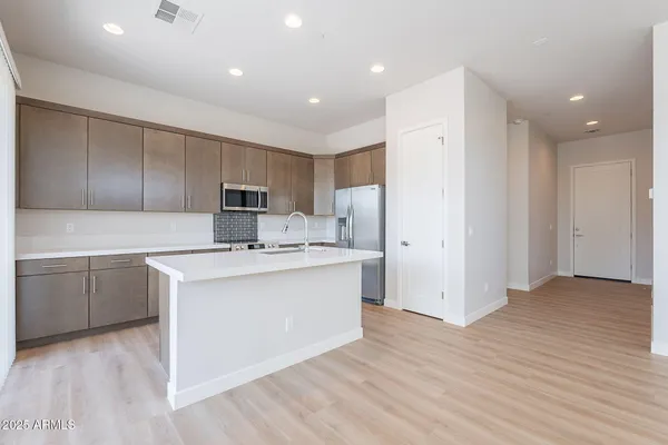 a kitchen with a refrigerator sink and cabinets