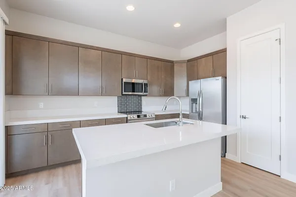 a kitchen with stainless steel appliances a refrigerator sink and microwave