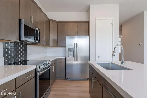 a kitchen with stainless steel appliances granite countertop a sink stove and refrigerator