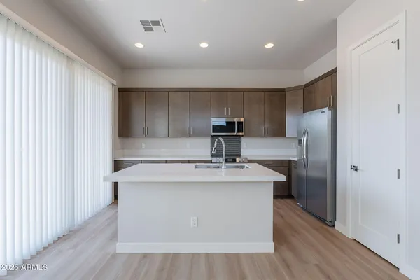 a kitchen with kitchen island a sink stove and refrigerator