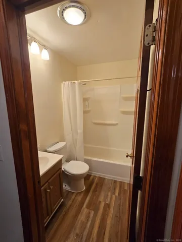 a bathroom with a sink a toilet a mirror and shower